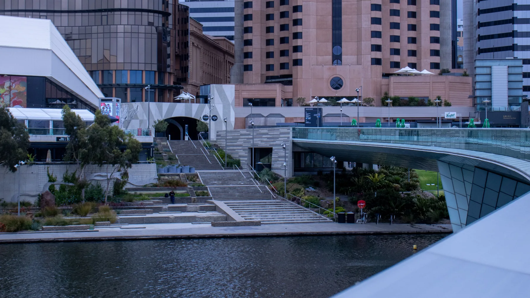 Adelaide’s riverbank buildings and curved footbridge beside the River Torrens