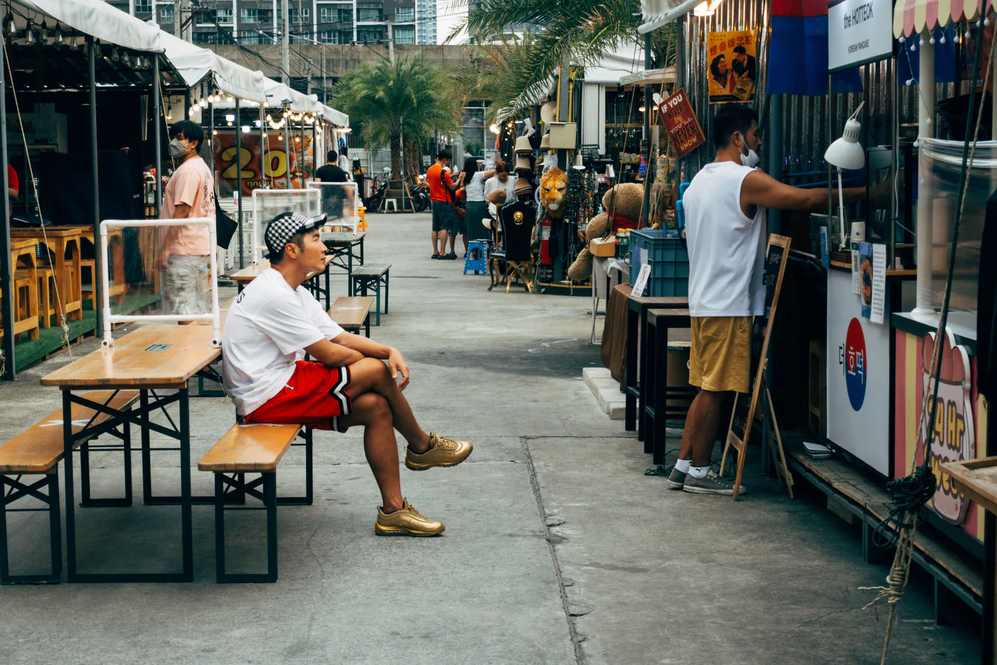 Shoppers among small street-market shops in Bangkok.