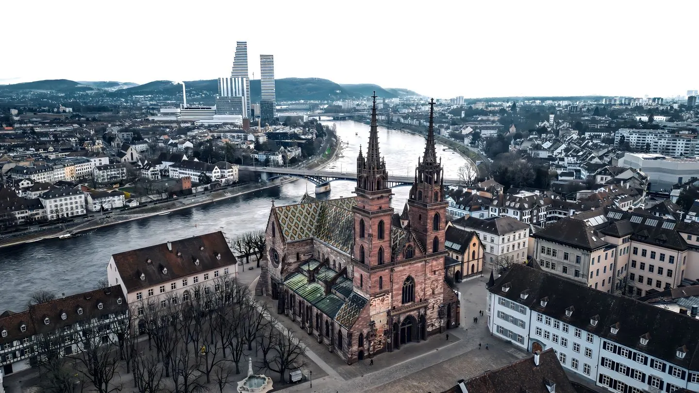 Basel Münster’s twin towers and patterned roof above the Rhine, with the Roche towers beyond