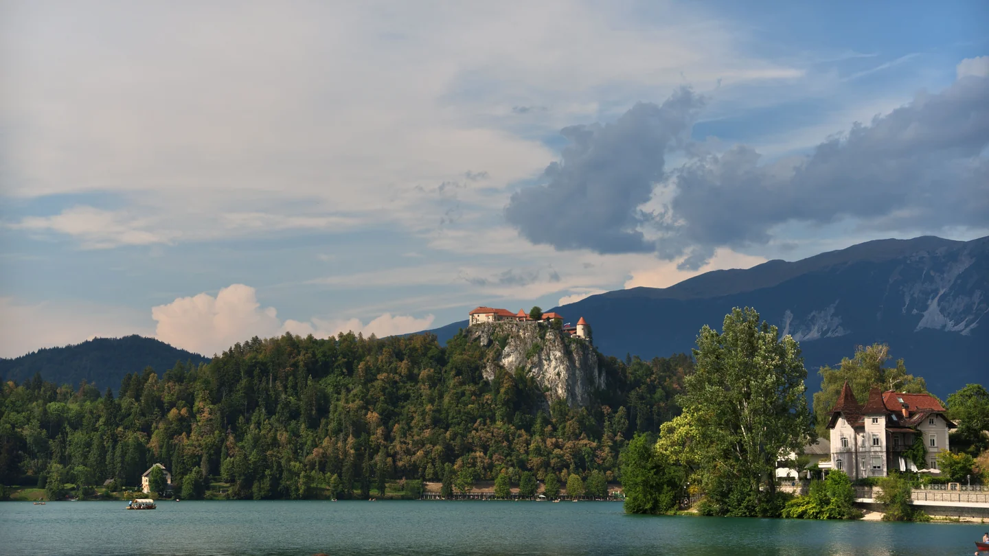 Bled Castle on its rocky wooded cliff above Lake Bled