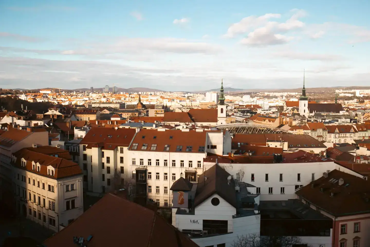 Brno’s historic rooftops and church towers in warm evening light