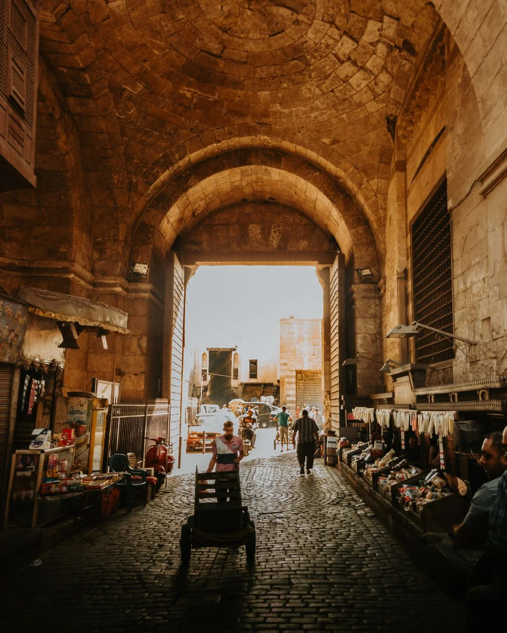 A vaulted stone gateway lined with market stalls in Cairo’s Khan el-Khalili