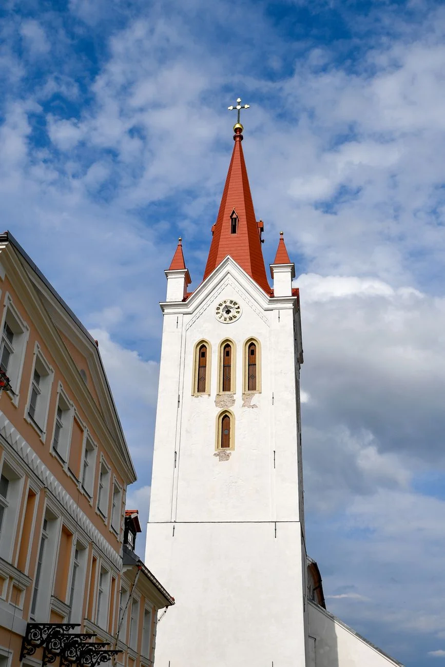 St John’s Church’s white clock tower and red spire above Cēsis Old Town