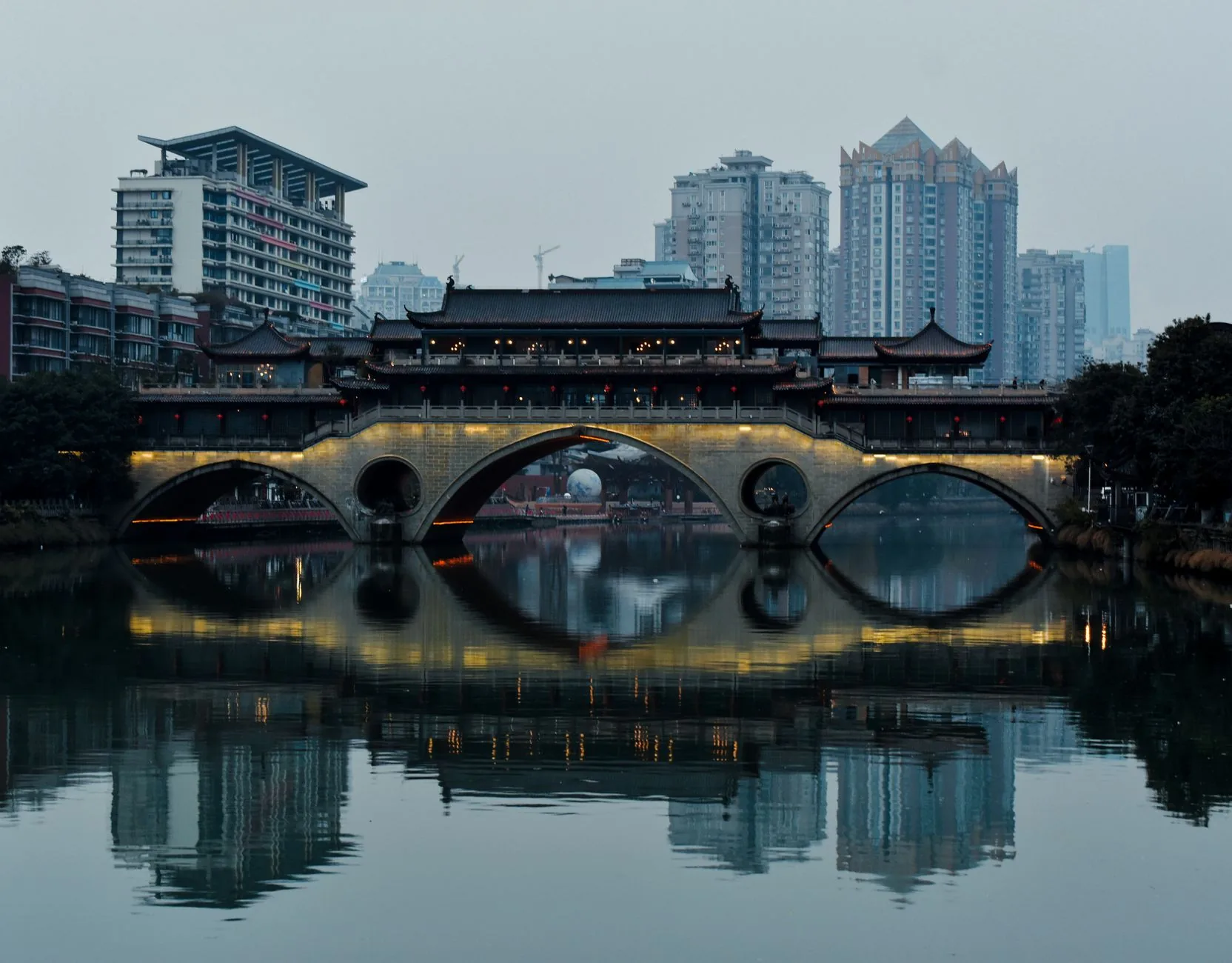 The covered arches of Anshun Bridge reflected in Chengdu’s Jin River