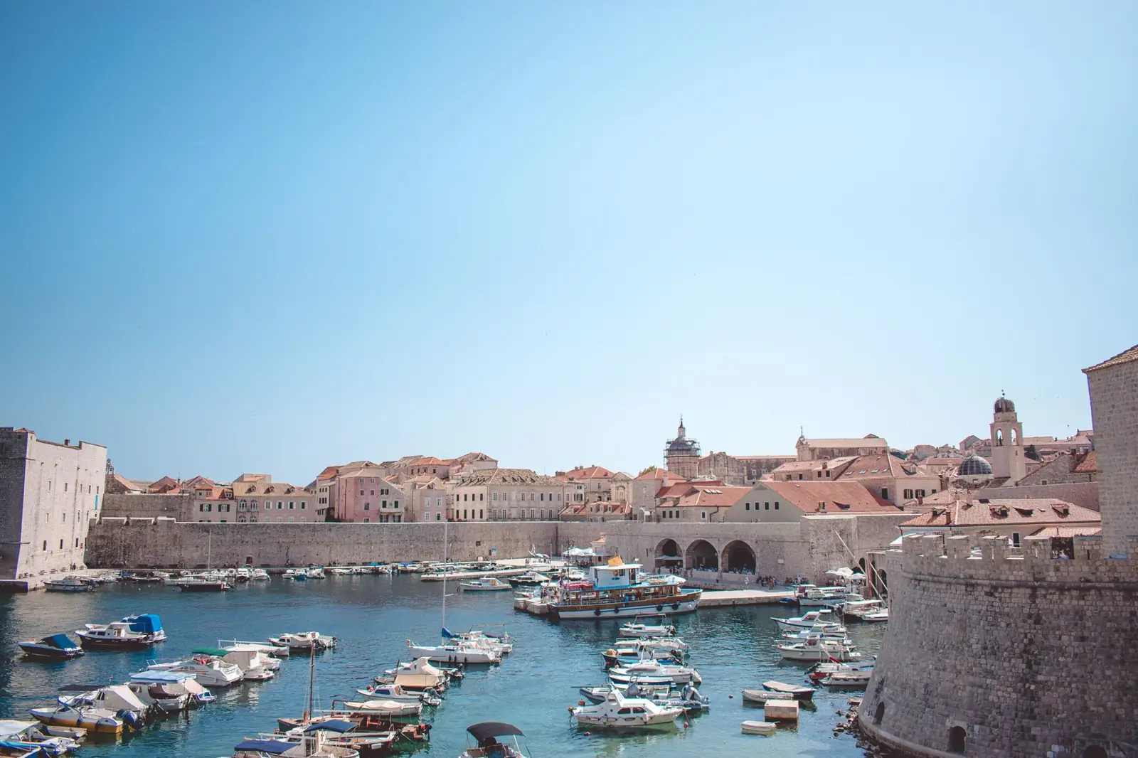 Boats in Dubrovnik’s Old City Port beneath the historic buildings