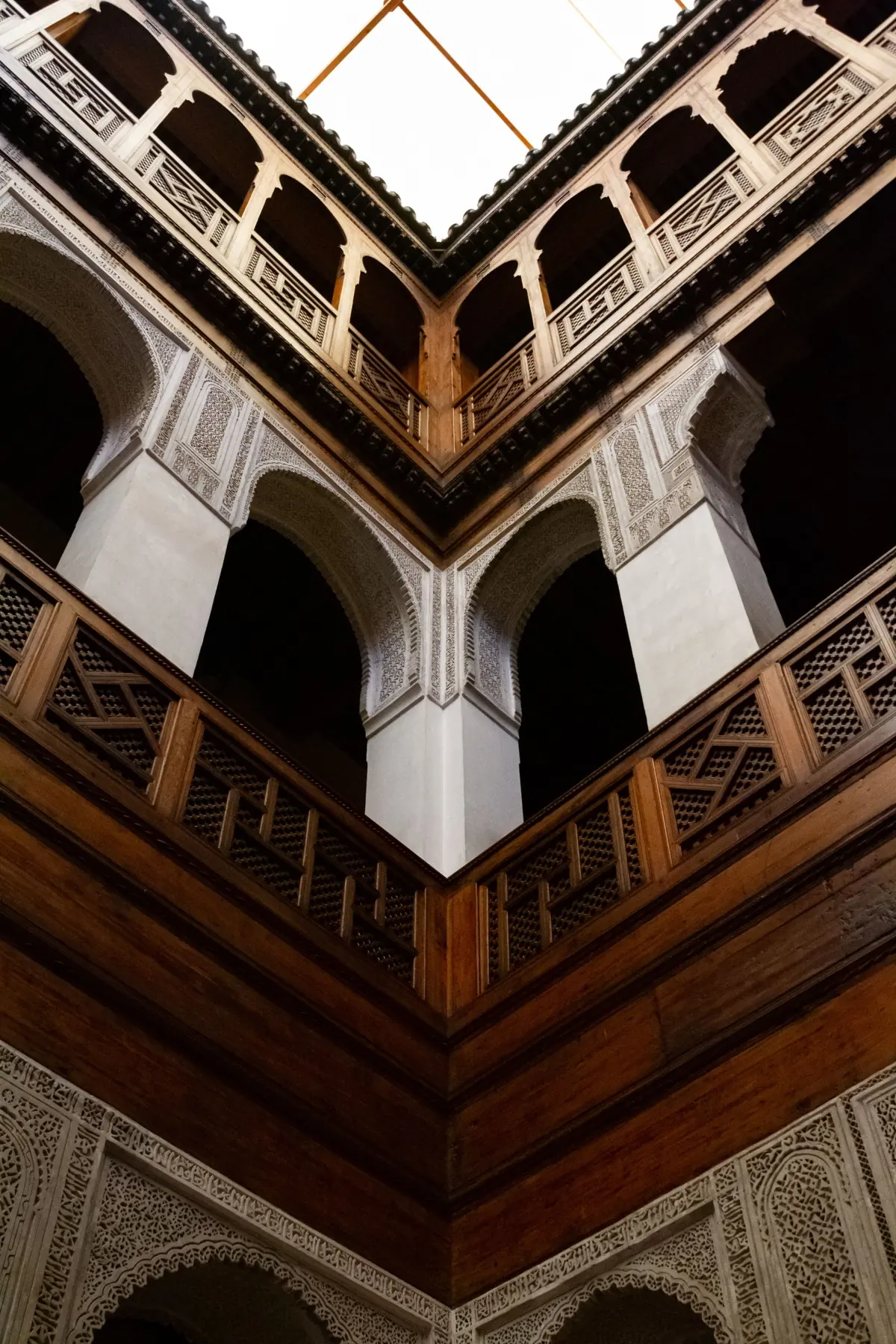 Explore intricate Moorish architecture of Museo Nejjarine, Fes, Morocco. Elegant wooden carvings and arches.