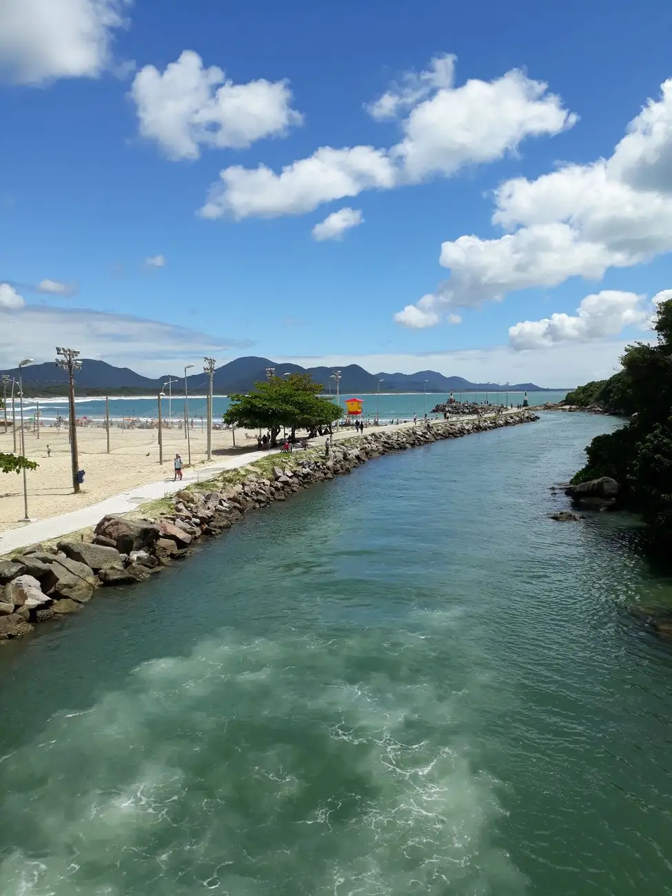 Barra da Lagoa channel mouth and its stone jetty beside the beach
