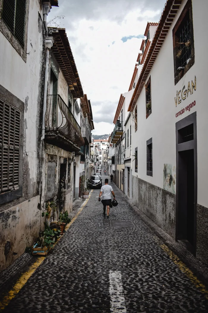 Pedestrian in a narrow cobbled Funchal street