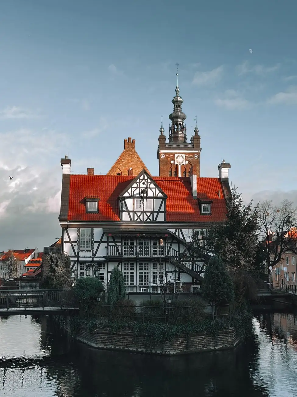 The half-timbered millers’ guild house beside Gdańsk’s Radunia Canal, with St Catherine’s Church tower behind it