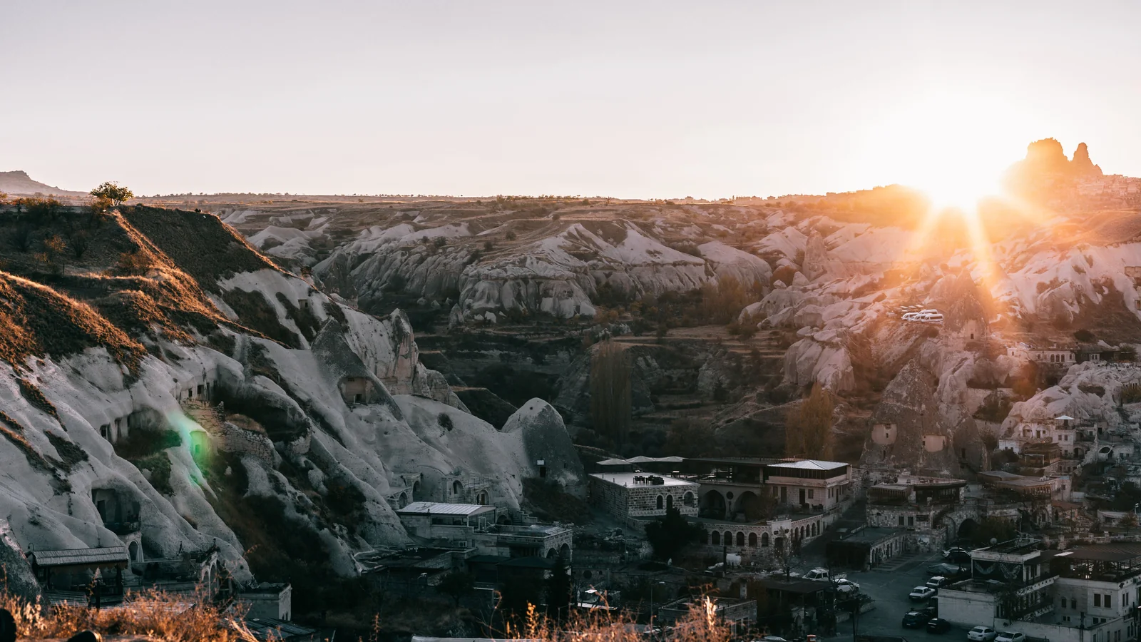 Sunlight reaching the sculpted slopes and cave buildings on the edge of Göreme.