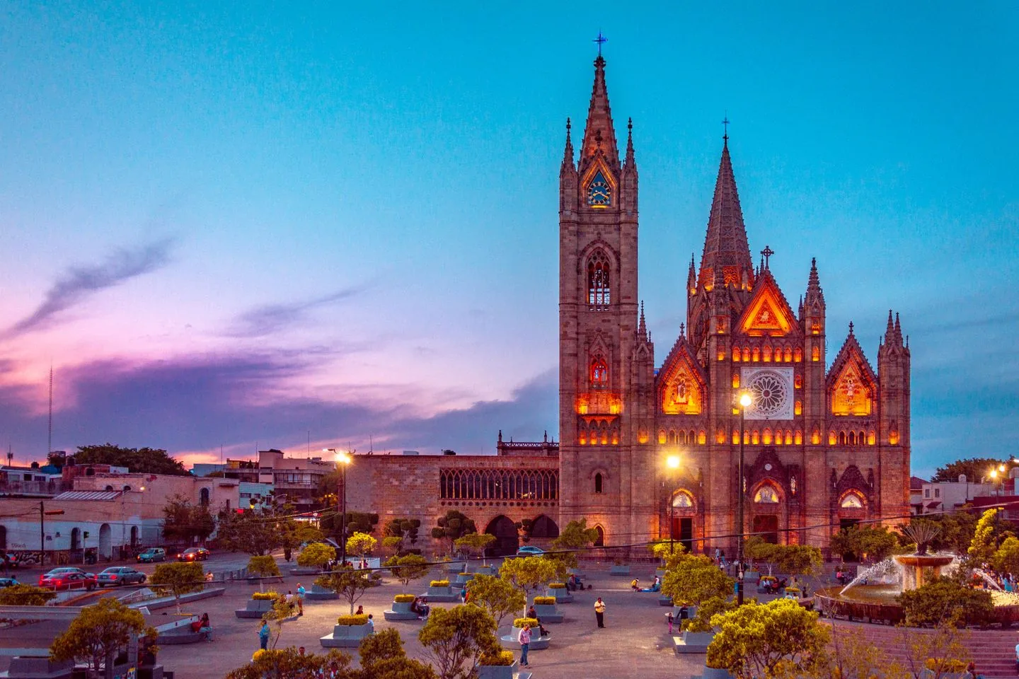 Illuminated stone tower, pointed arches and rose window of Guadalajara’s Templo Expiatorio at dusk