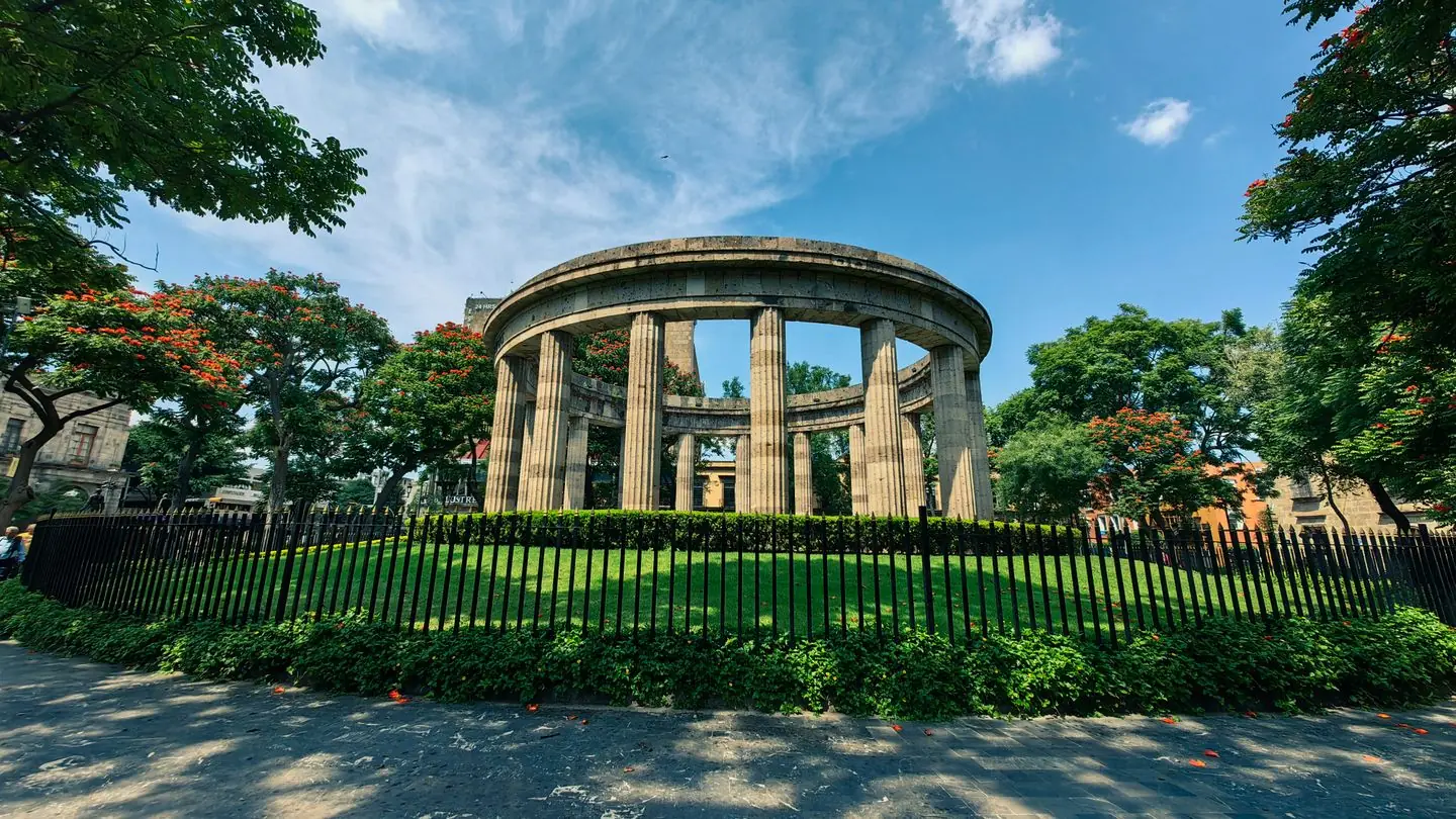 Circular stone colonnade of the Rotonda de los Jaliscienses Ilustres surrounded by trees