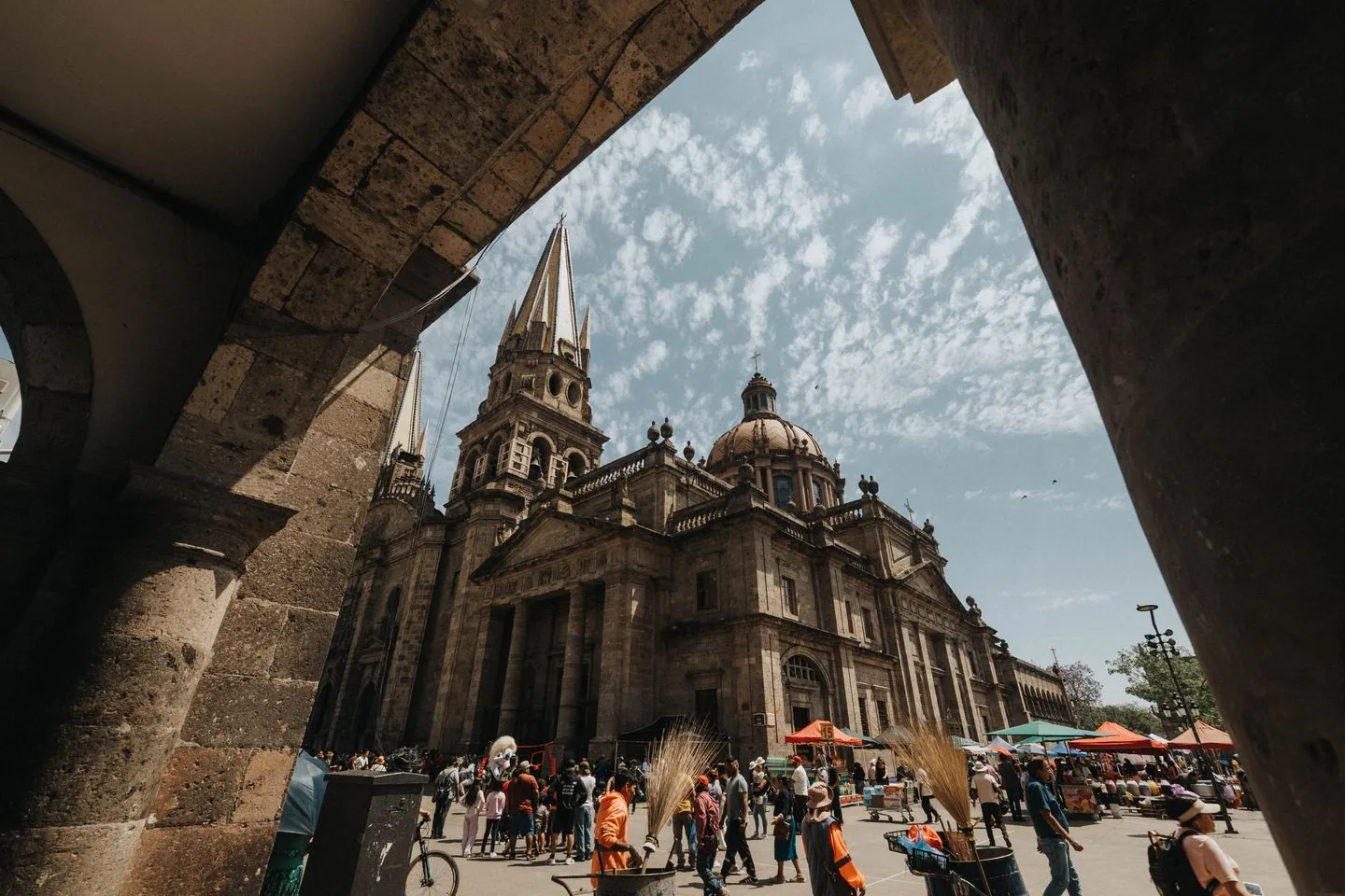 Guadalajara Cathedral seen through a stone arch beside its public square