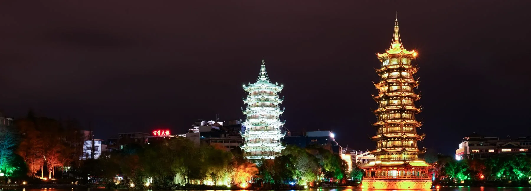 The Sun and Moon Pagodas illuminated and reflected in Shanhu Lake in Guilin