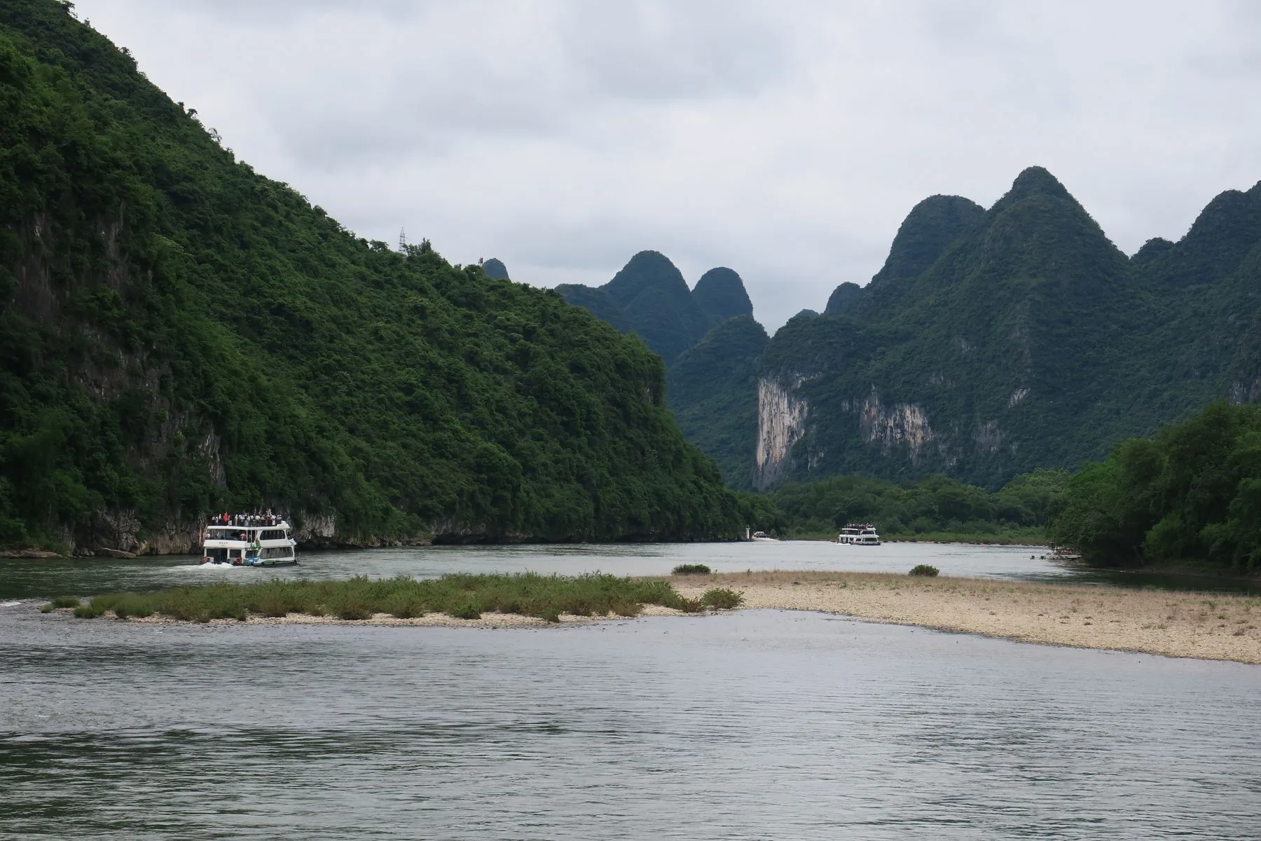 Passenger boats on the Li River between limestone karst cliffs in Guilin’s scenic region