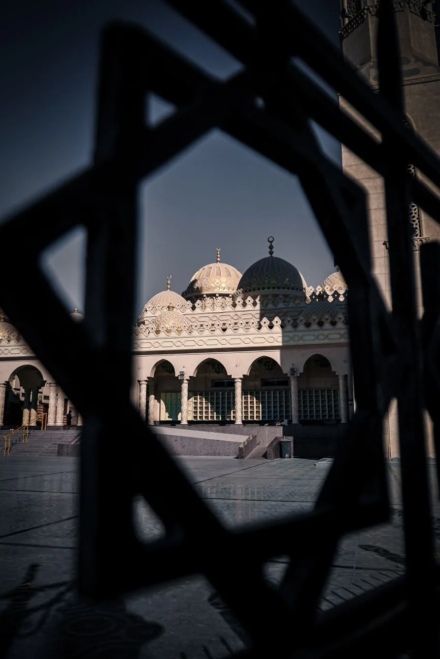 Pale domes and arcades of El Mina Mosque in Hurghada, framed by a geometric screen