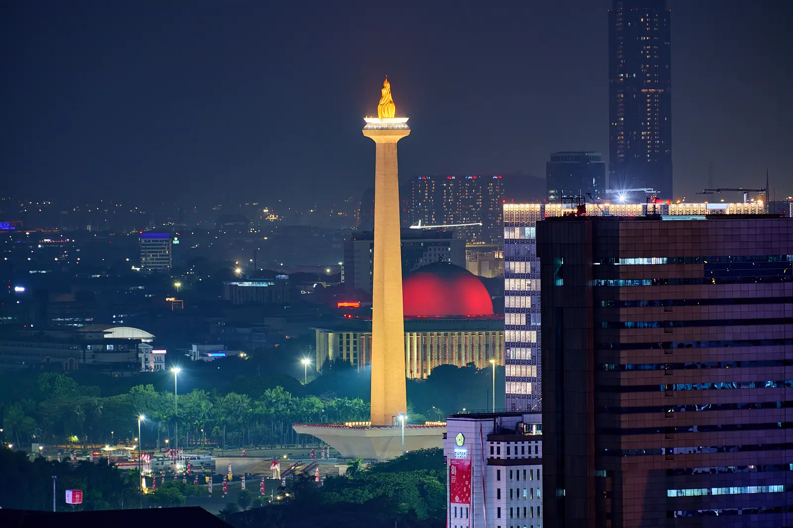 Monas lit at night above Jakarta’s central skyline