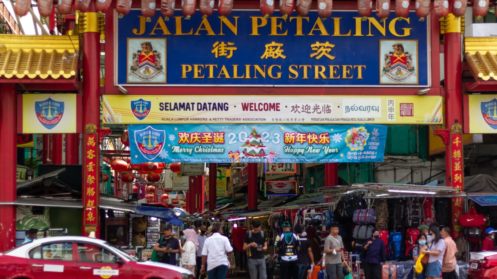 The Jalan Petaling gateway above market stalls and traffic in Kuala Lumpur’s Chinatown.