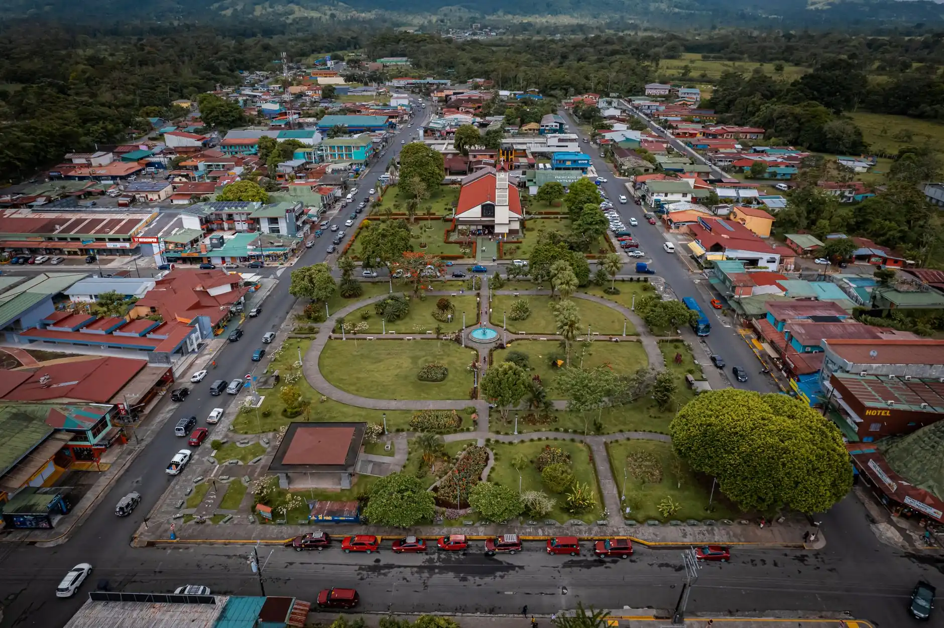 La Fortuna central park, fountain and red-roofed church seen from above