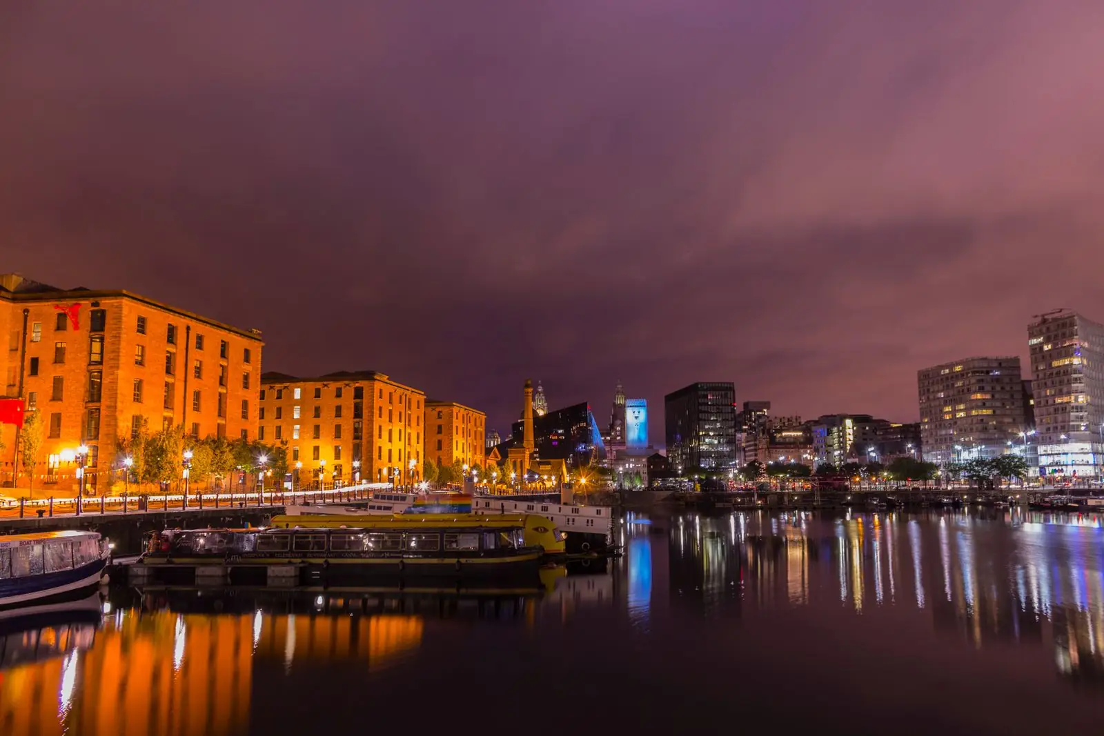 Royal Albert Dock buildings and pedestrian bridge lit at dusk