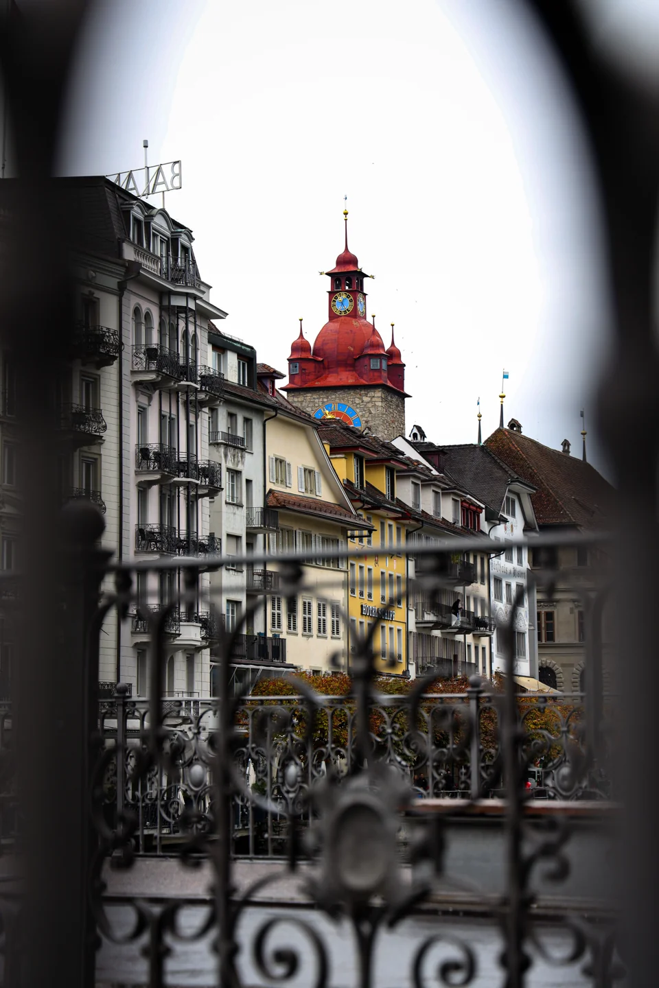 Lucerne Town Hall clock tower framed by the ornate Reusssteg railing