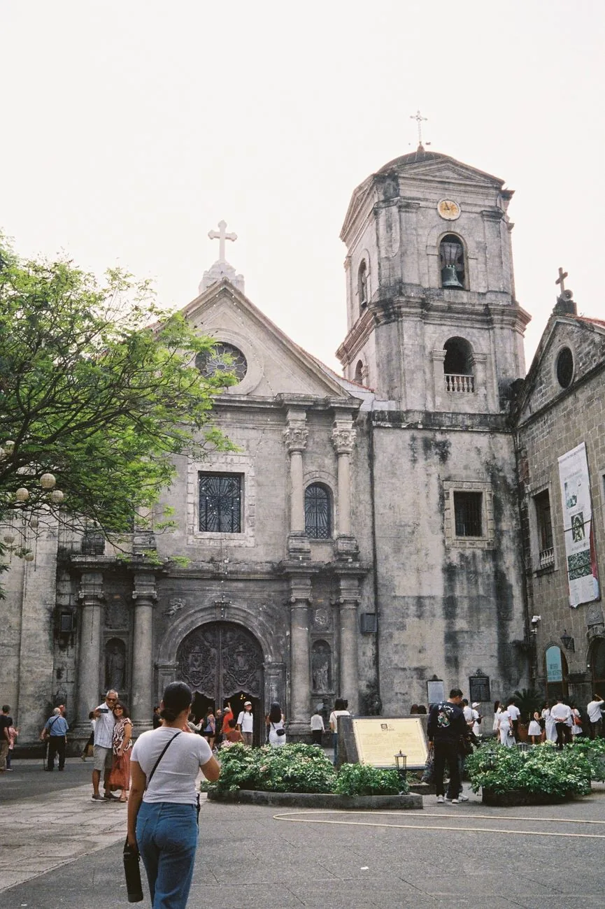 Stone facade and bell tower of San Agustin Church beside its courtyard in Intramuros