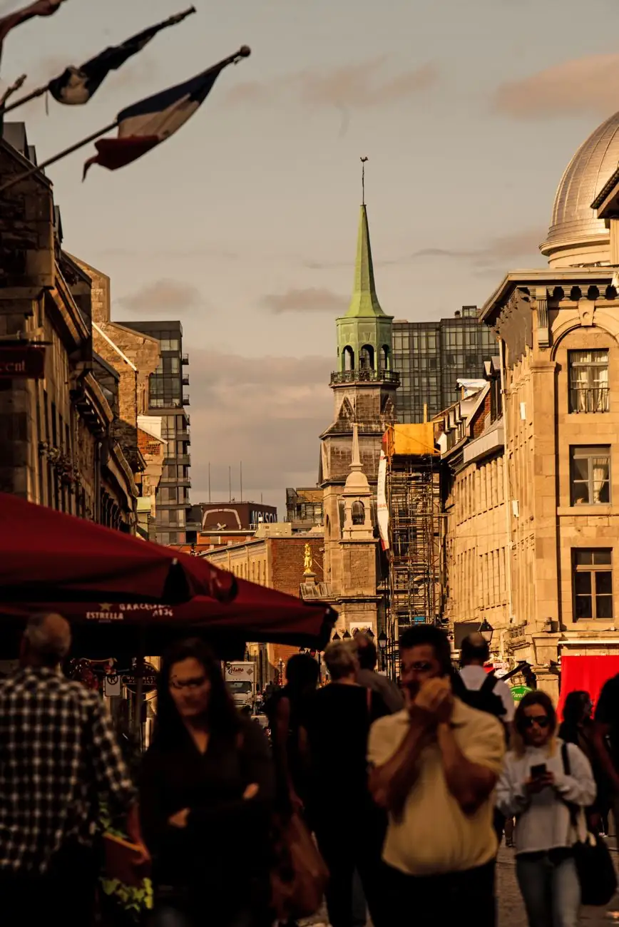 Historic Old Montréal street with the Bonsecours chapel spire visible beyond the crowd