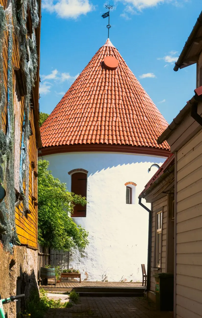 Pärnu’s whitewashed Red Tower and red conical roof viewed through its narrow courtyard approach
