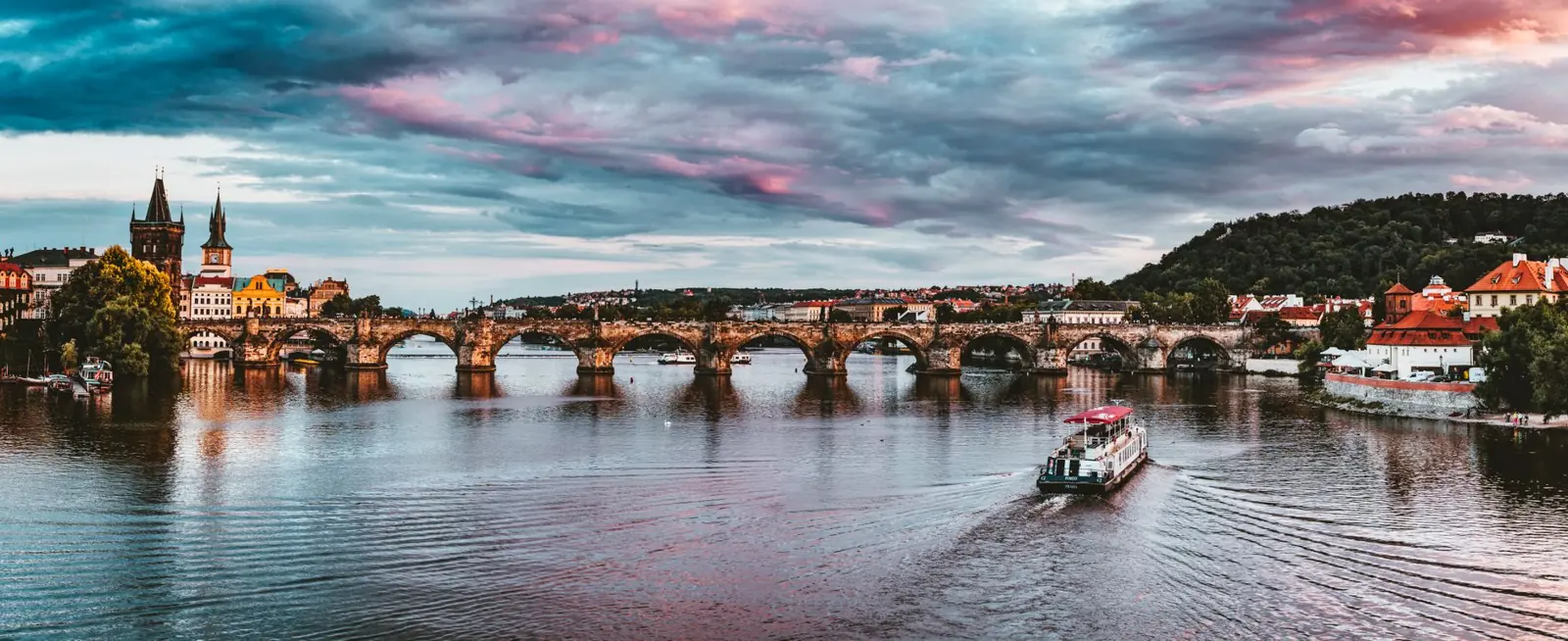 Charles Bridge’s stone arches and towers over the Vltava at sunset