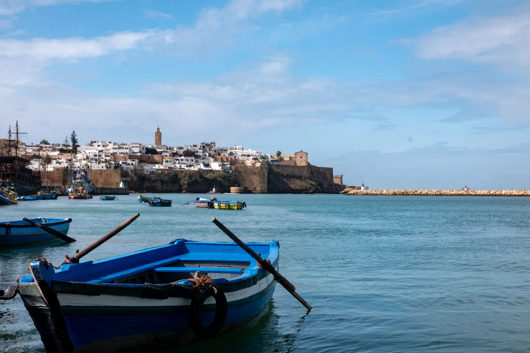 Blue rowing boats on the Bouregreg with Rabat’s Oudayas kasbah behind