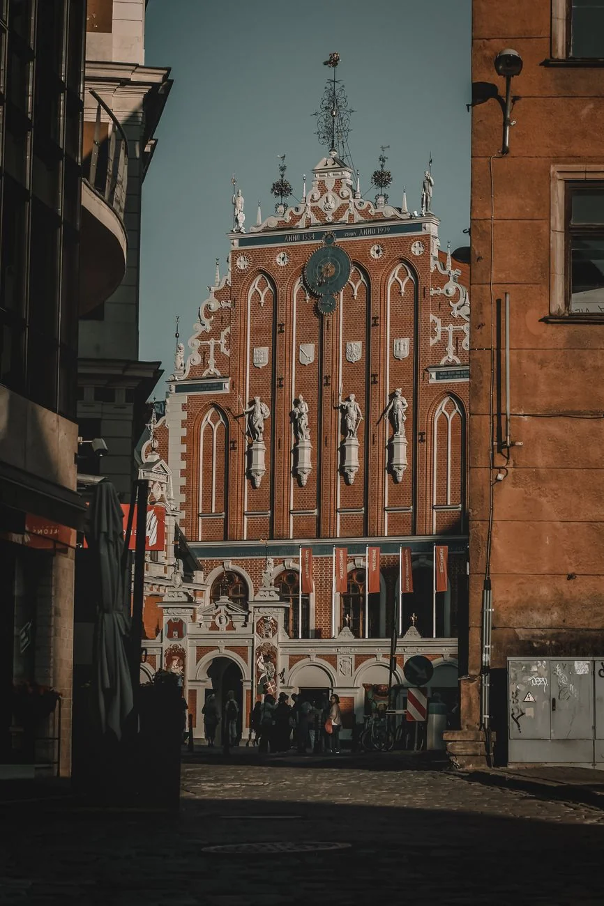 Riga’s House of the Blackheads, with its ornate clock and decorated gable seen between Old Town buildings