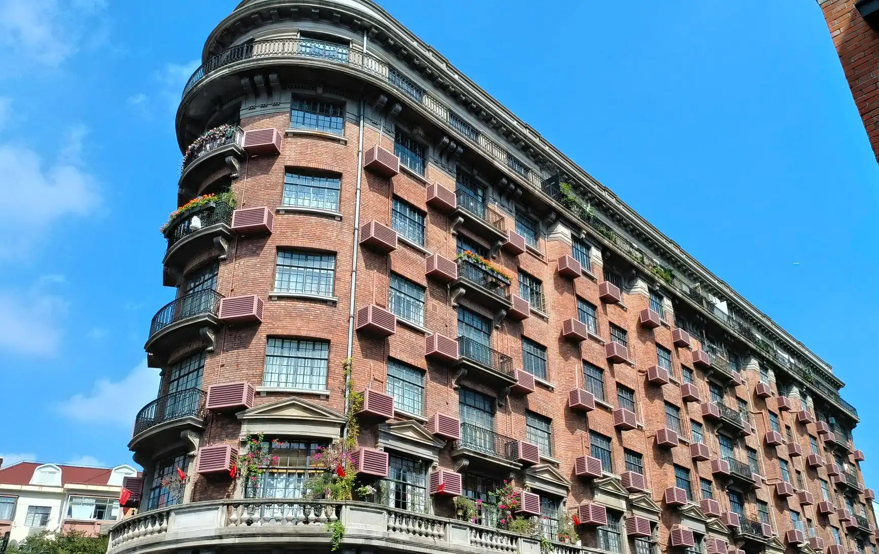 The curved red-brick façade and balconies of Wukang Mansion in Shanghai