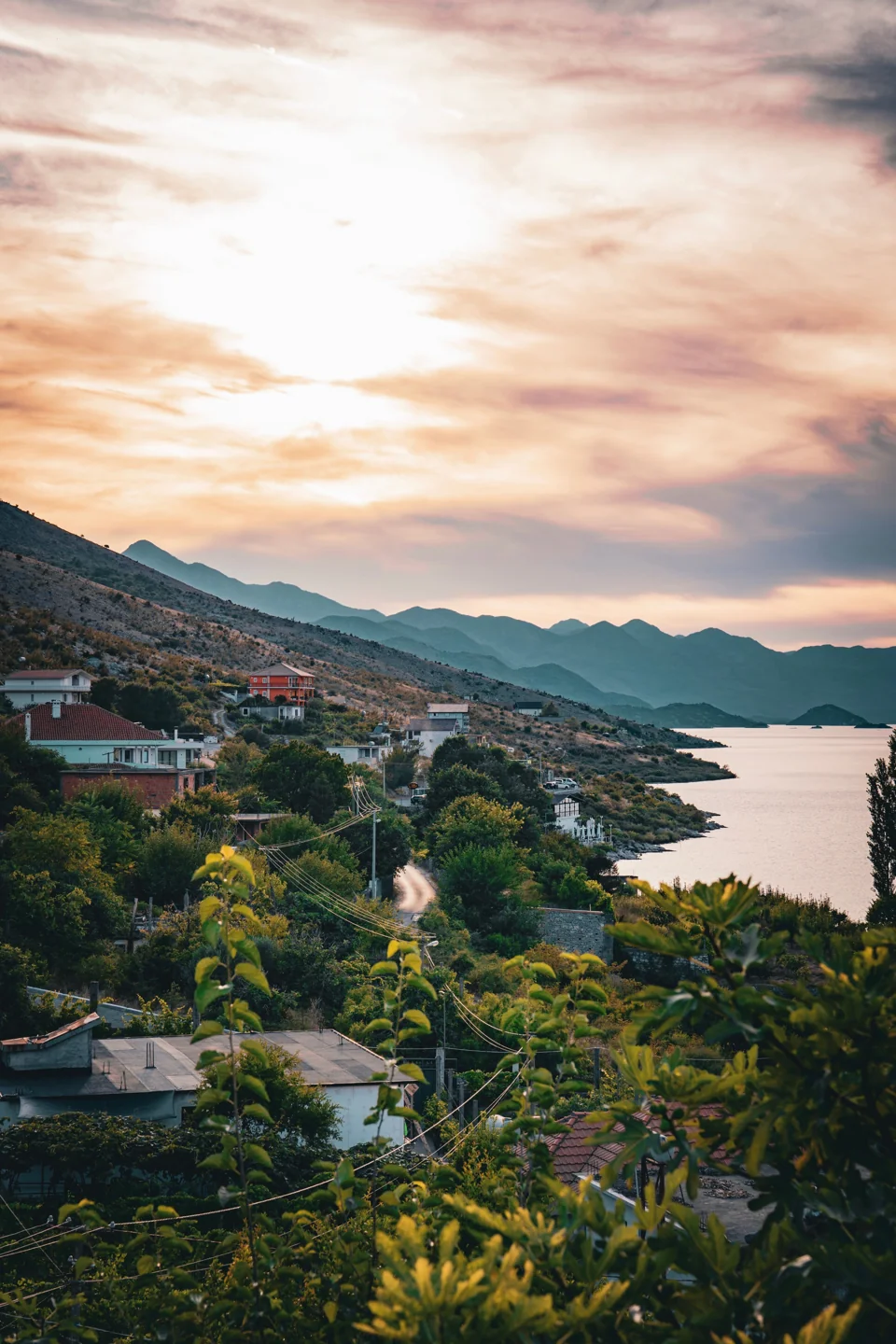 Houses and hillside along the Albanian shore of Lake Shkodra near Shiroka at sunset