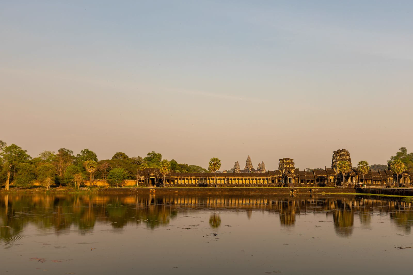 Angkor Wat temple galleries reflected in the surrounding water.