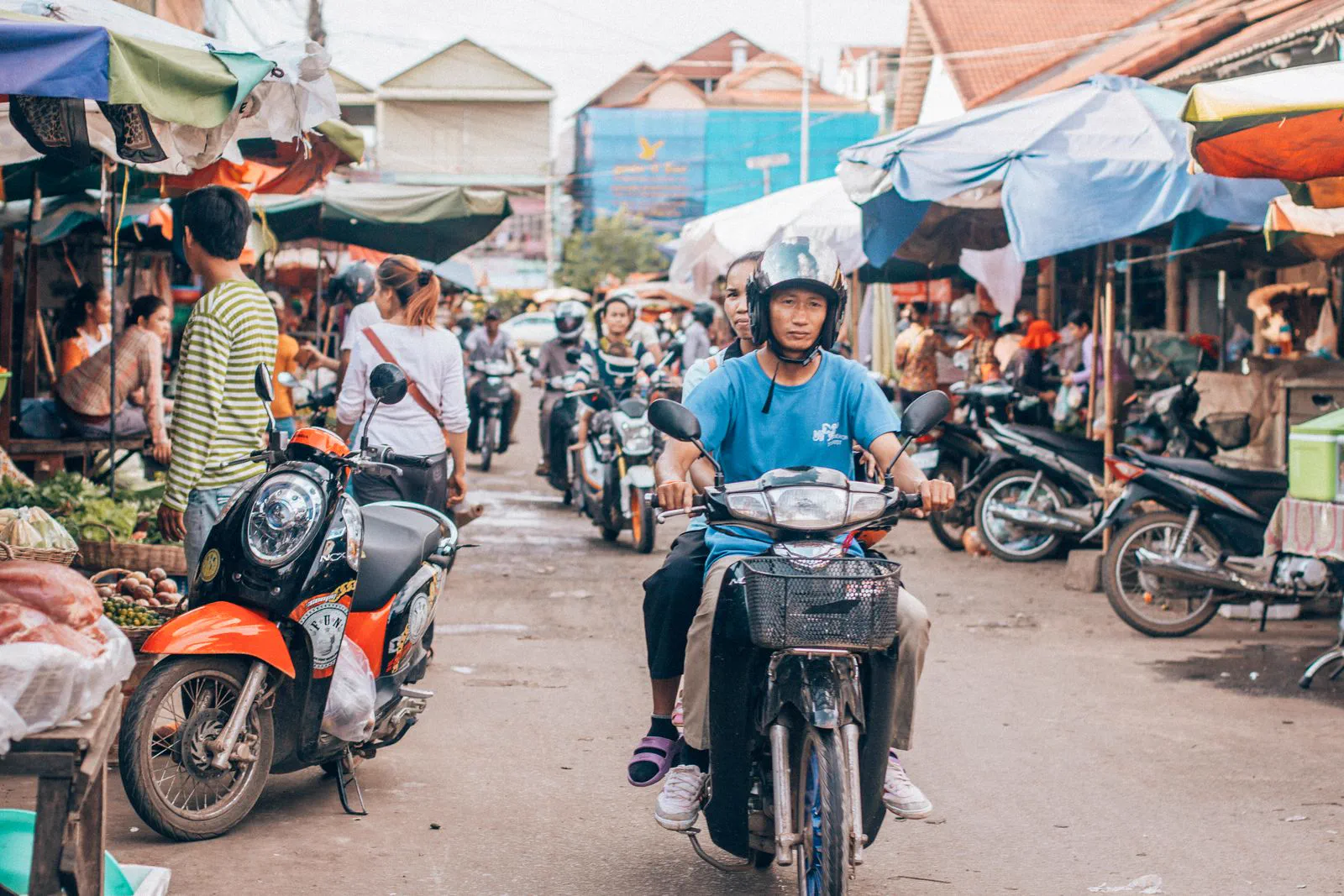 Motorbikes pass a busy street market in central Siem Reap.
