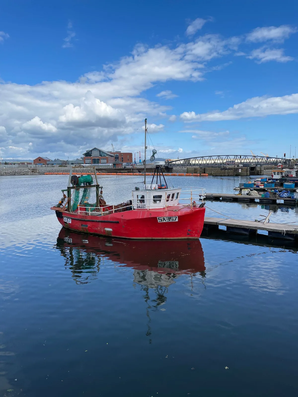 A red fishing boat moored in Swansea Marina