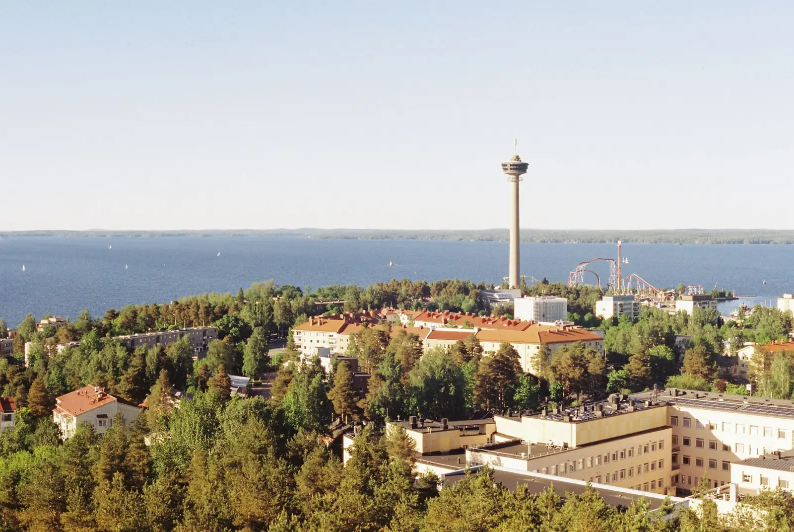 Aerial view of Tampere cityscape with Näsinneula tower and lake during a sunny day.