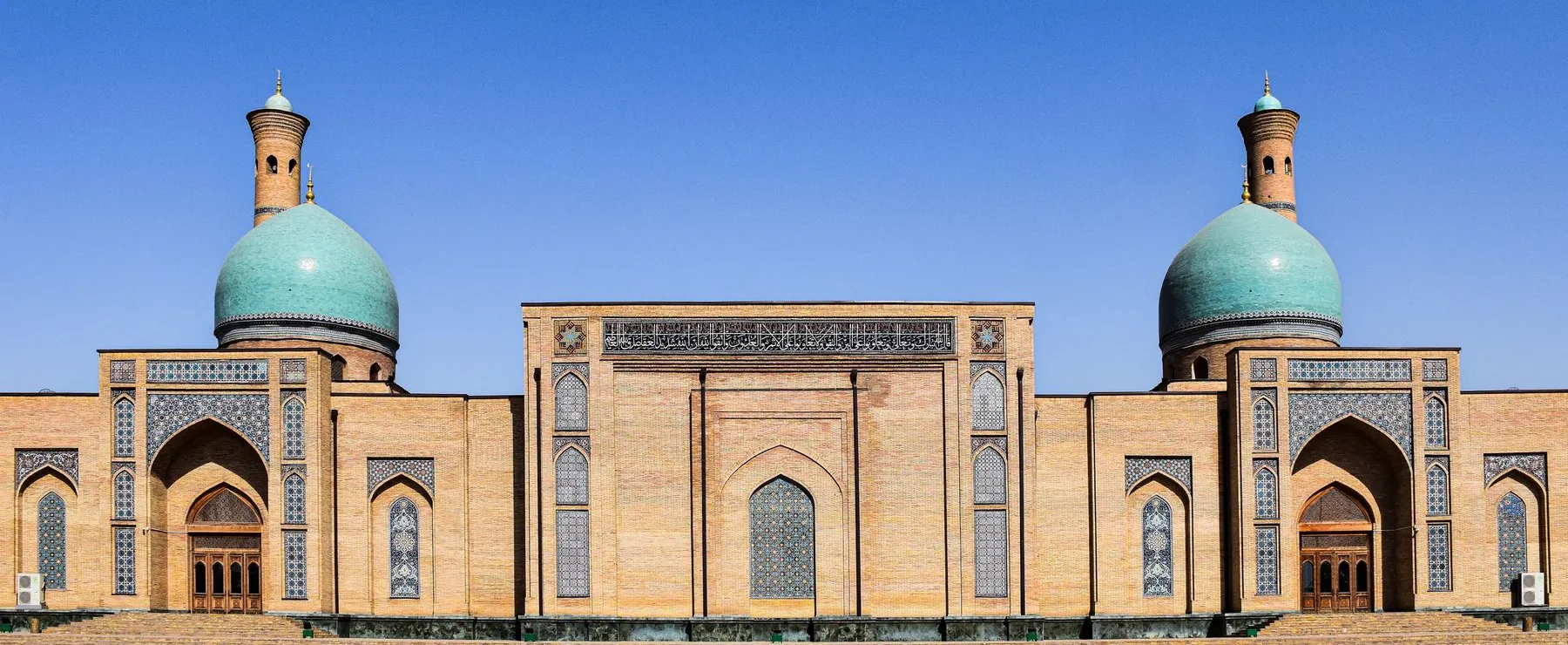 The turquoise domes and tiled main facade of Hazrati Imam Mosque in Tashkent