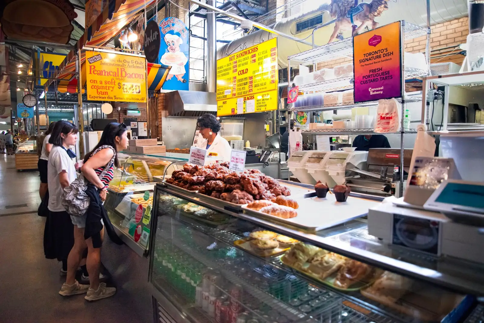 Carousel Bakery counter and peameal sandwich signs inside Toronto’s St. Lawrence Market