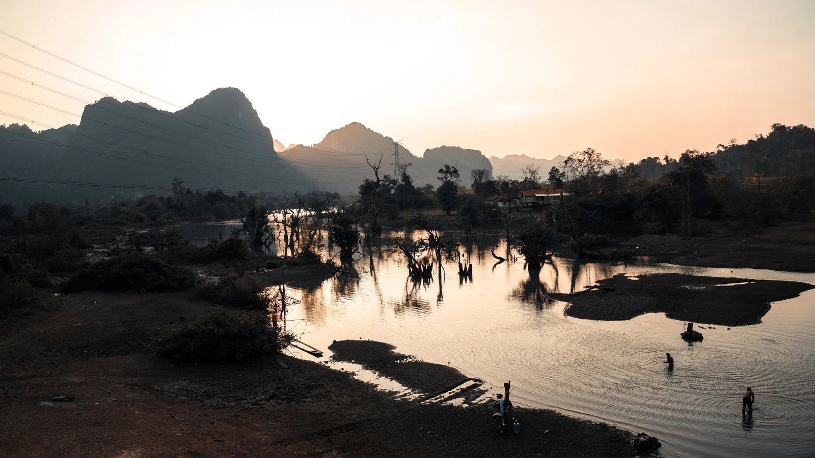 Evening light on the Nam Song River, with sandbars, trees and Vang Vieng’s karst skyline.