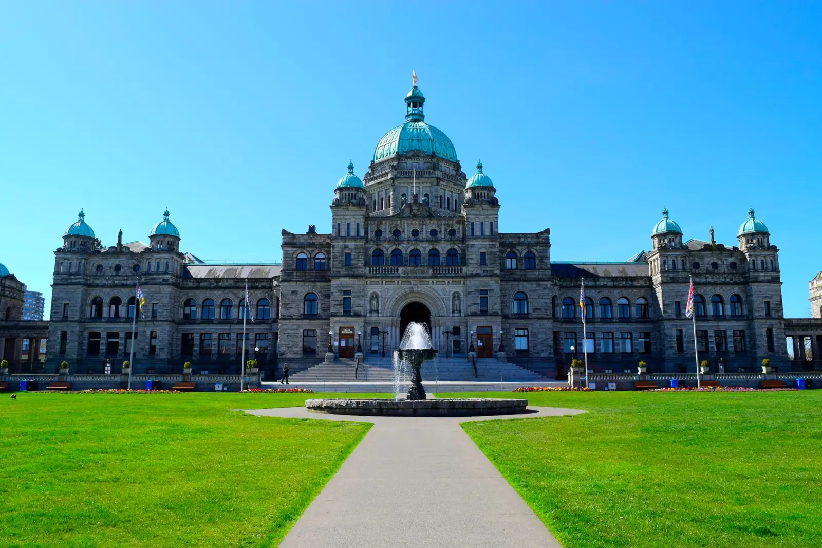 British Columbia Parliament Buildings and their central dome seen across the front lawn