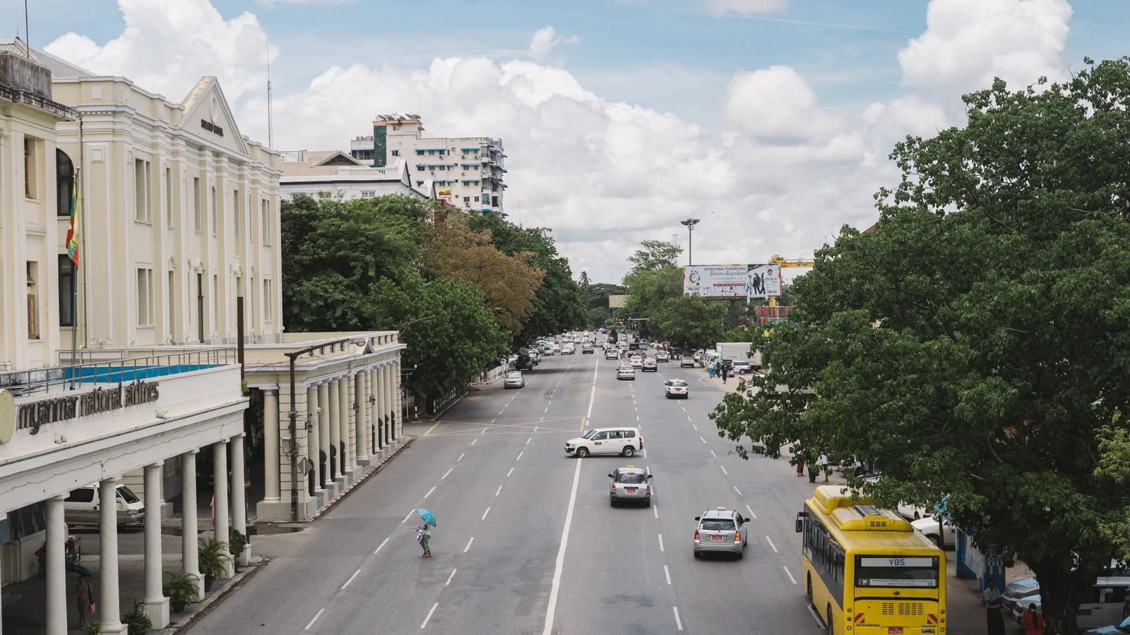 The Strand Hotel façade beside Strand Road traffic in downtown Yangon.