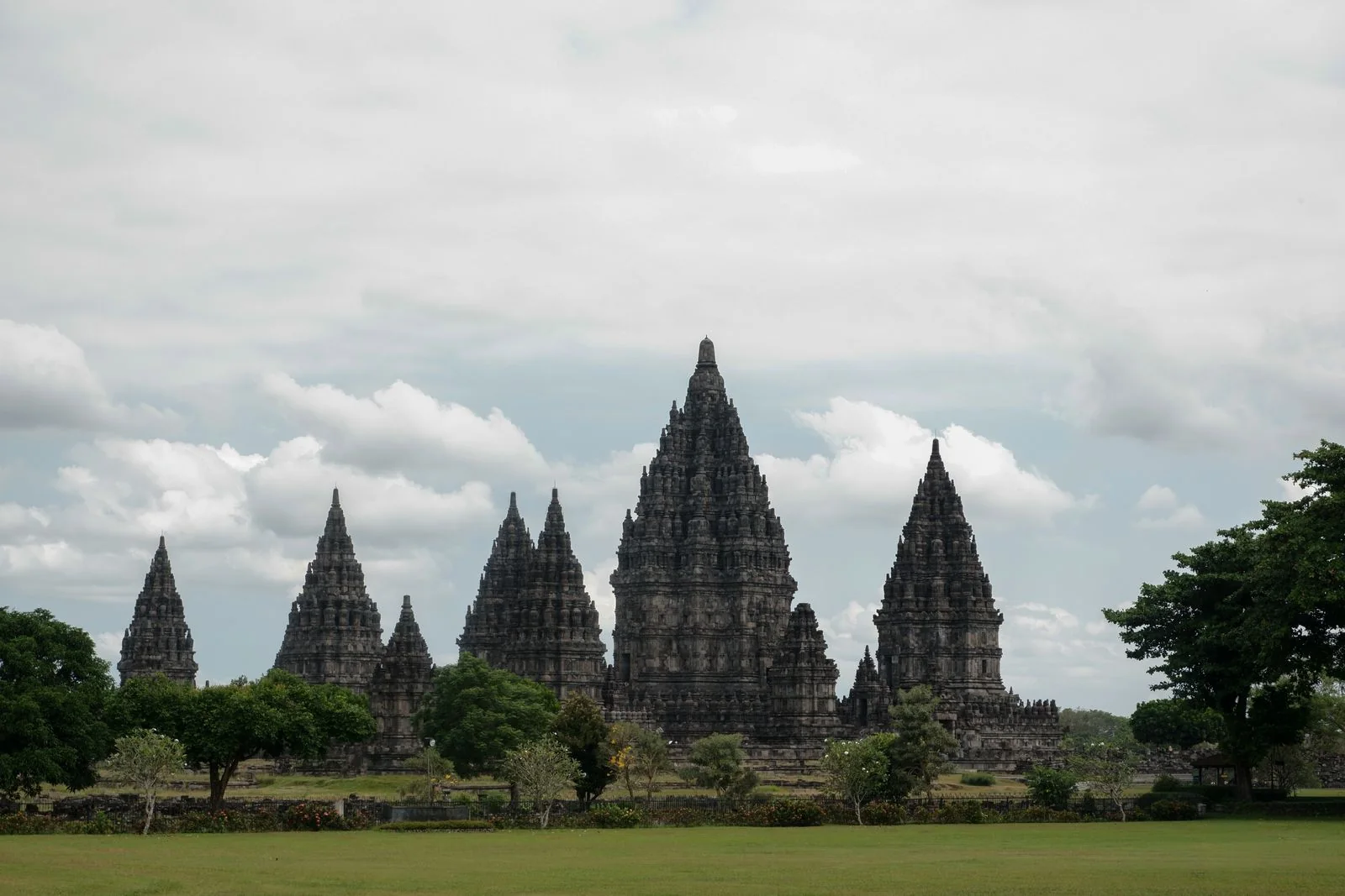 Prambanan’s stone temple spires rise against a cloudy sky