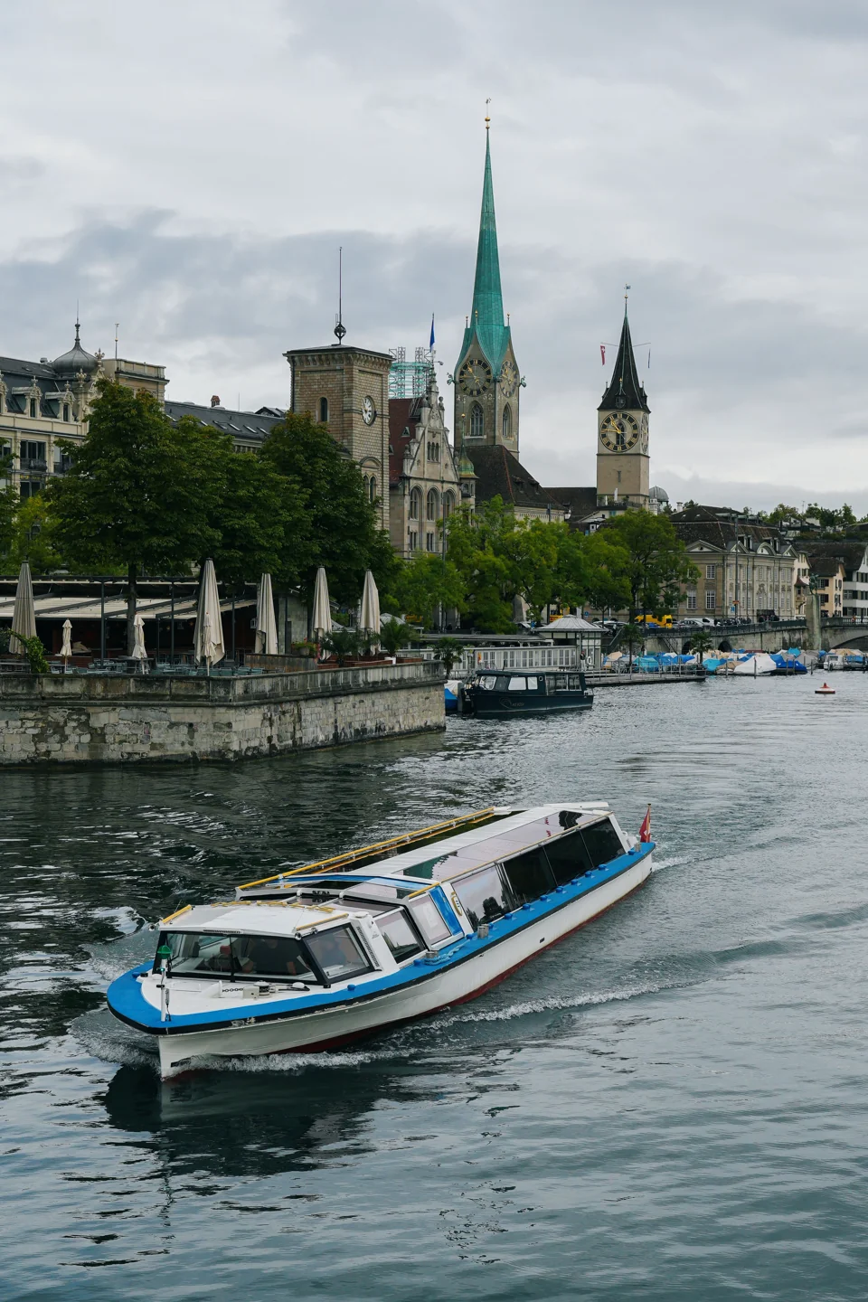 A low-profile Limmat river boat near Zürich’s Fraumünster spire
