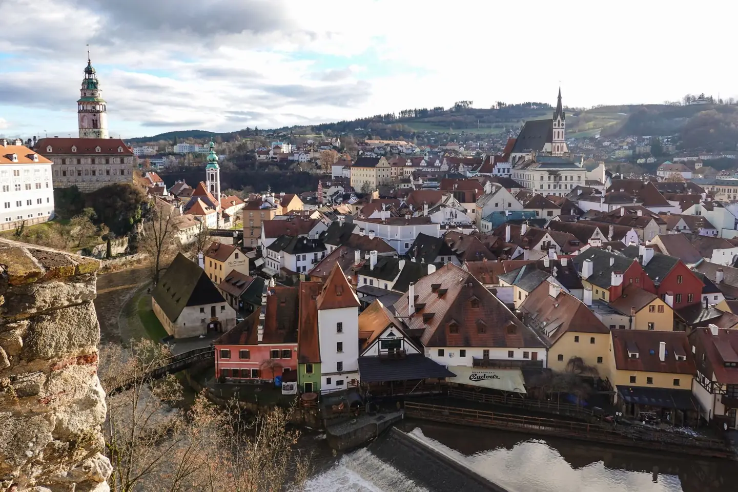 Český Krumlov’s river bend, Castle tower and Saint Vitus Church above red rooftops