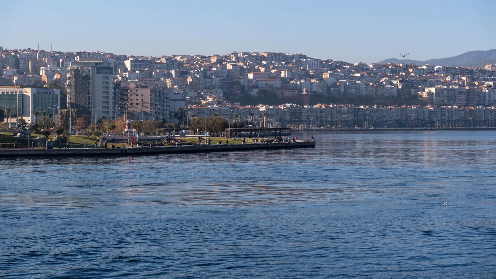 İzmir waterfront buildings and hillside neighbourhoods across the calm gulf.