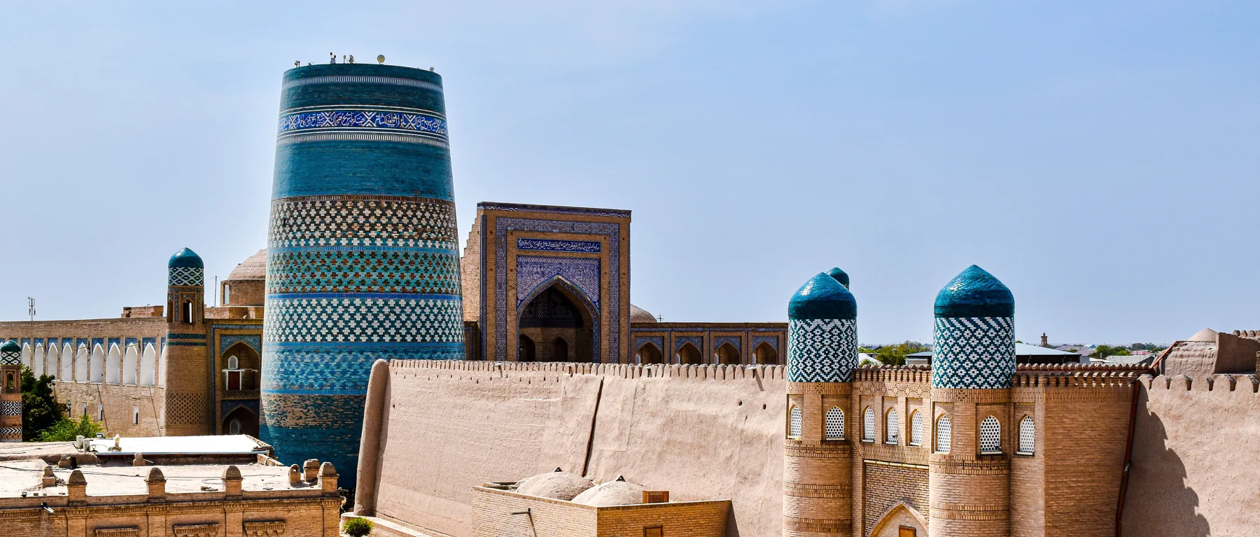 Kalta Minor and Muhammad Amin Khan Madrasah behind the tiled entrance towers of Kunya Ark in Khiva
