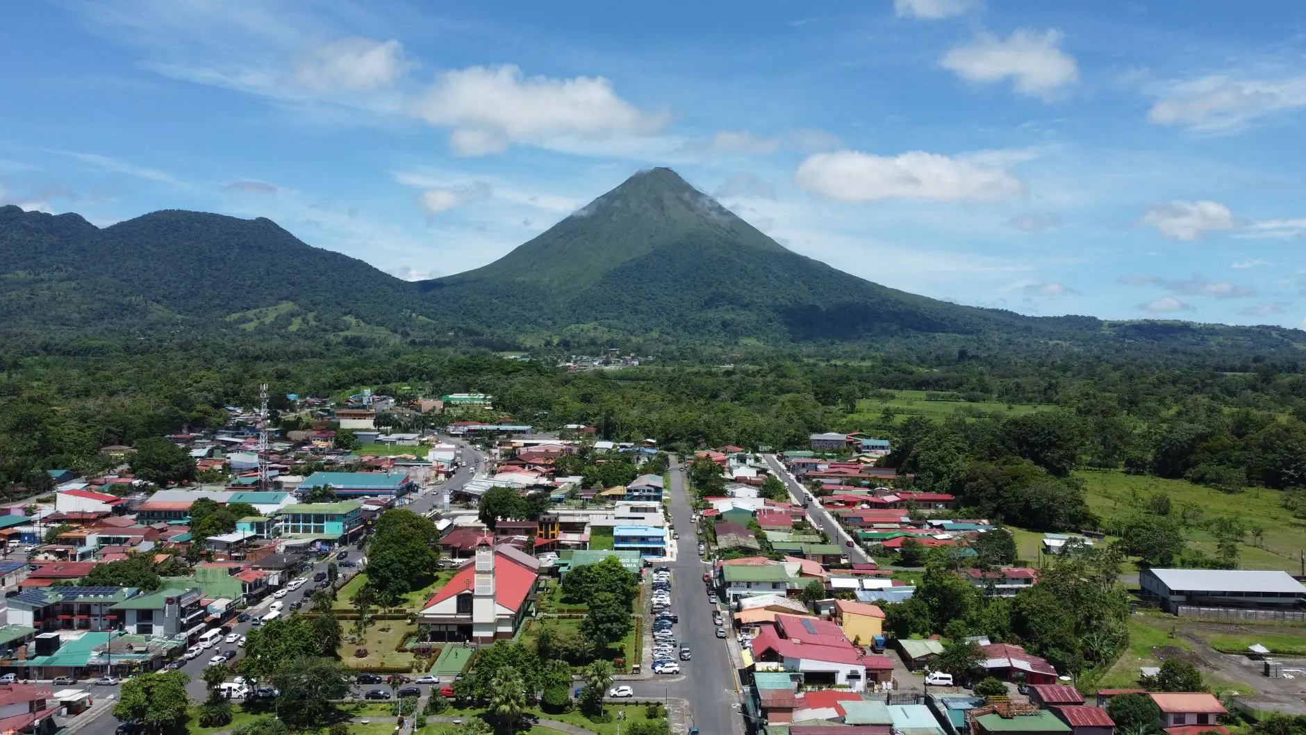 La Fortuna town and its red-roofed church below the green cone of Arenal Volcano