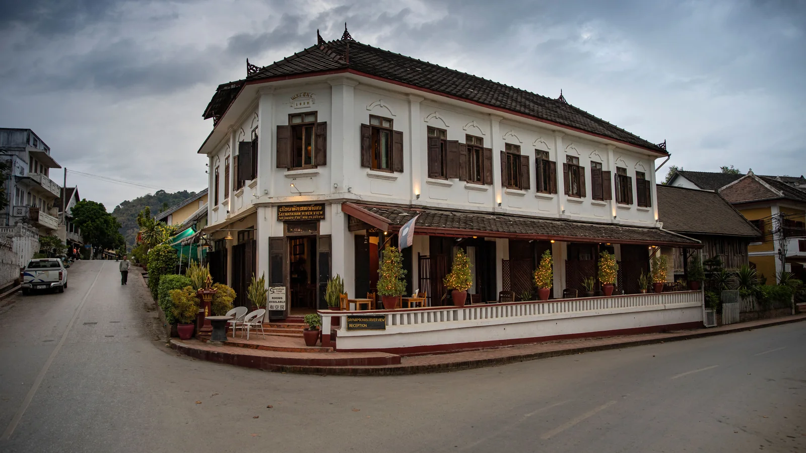 The white shuttered Saynamkhan River View building on a street corner in Luang Prabang.