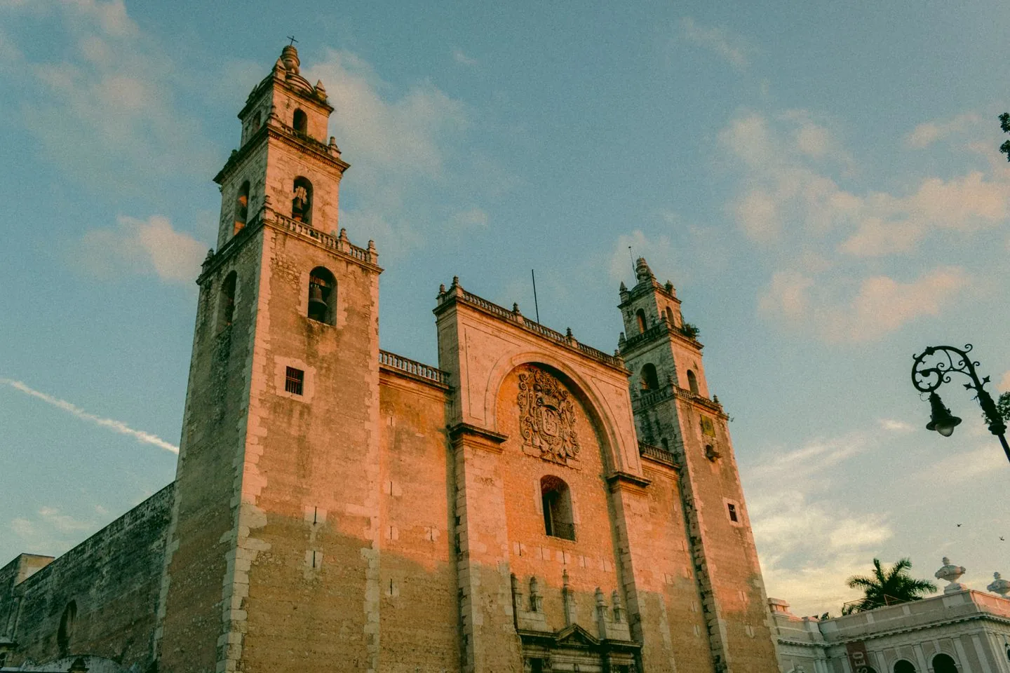 Stone facade and twin towers of Mérida Cathedral in warm evening light
